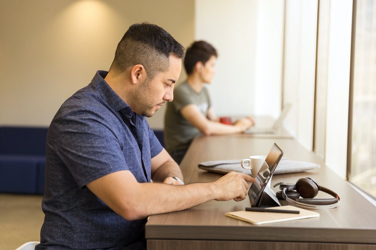 Student studies with tablet in lecture hall.