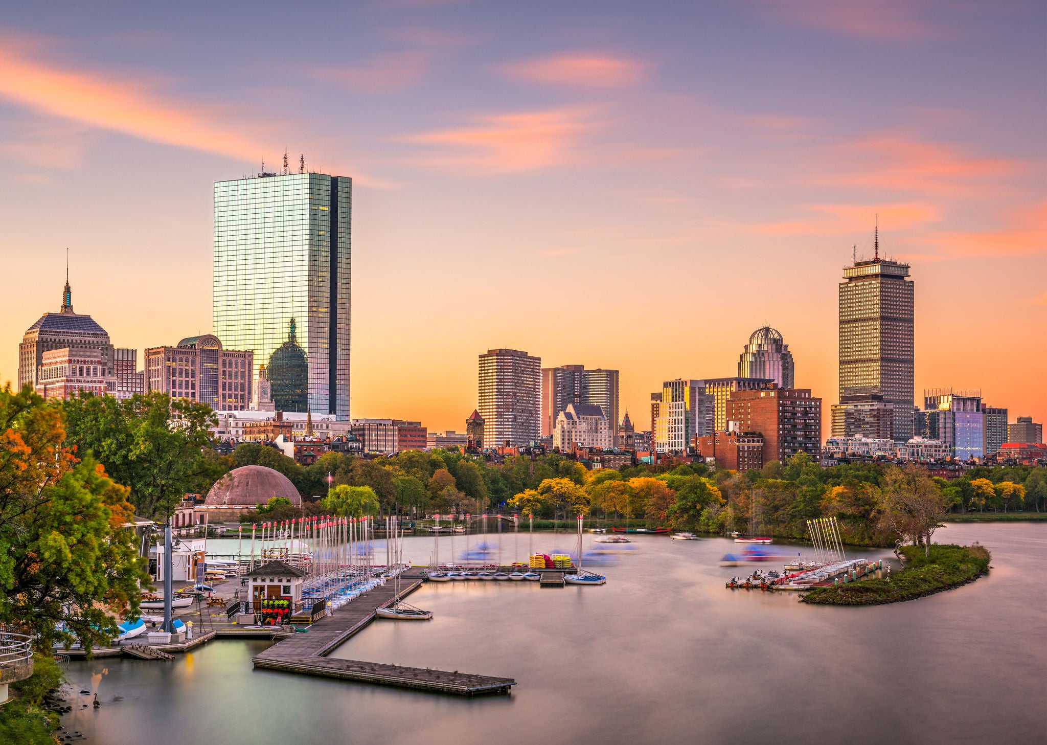 Boston, Massachusetts, skyline at dawn with the harbor in the foreground.