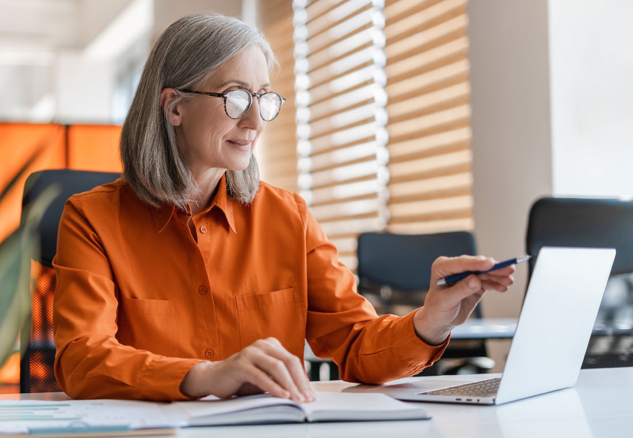 A woman works in an office on a laptop computer.