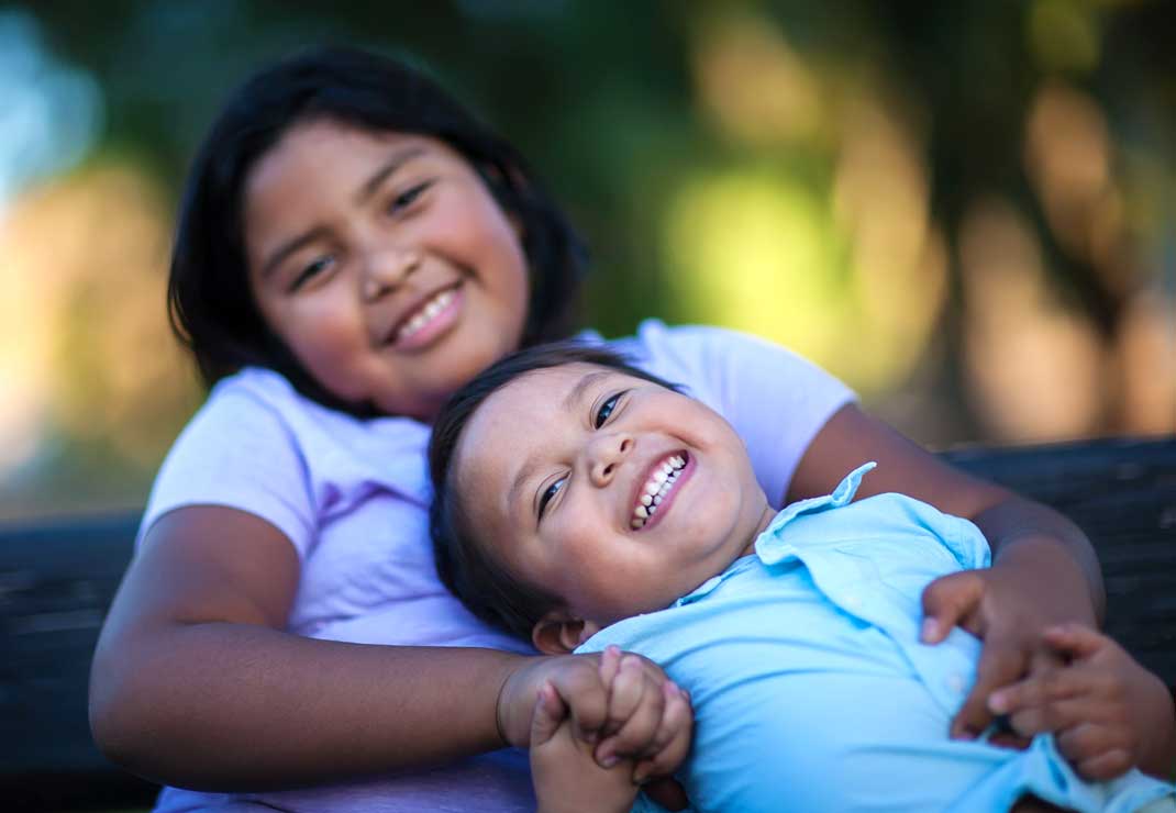 Two siblings having fun while playing outside