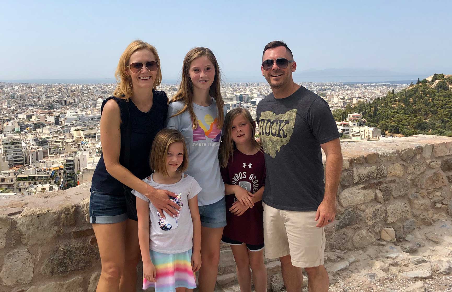 Slalom General Manager Channie Mize and family pose in front of a city backdrop.