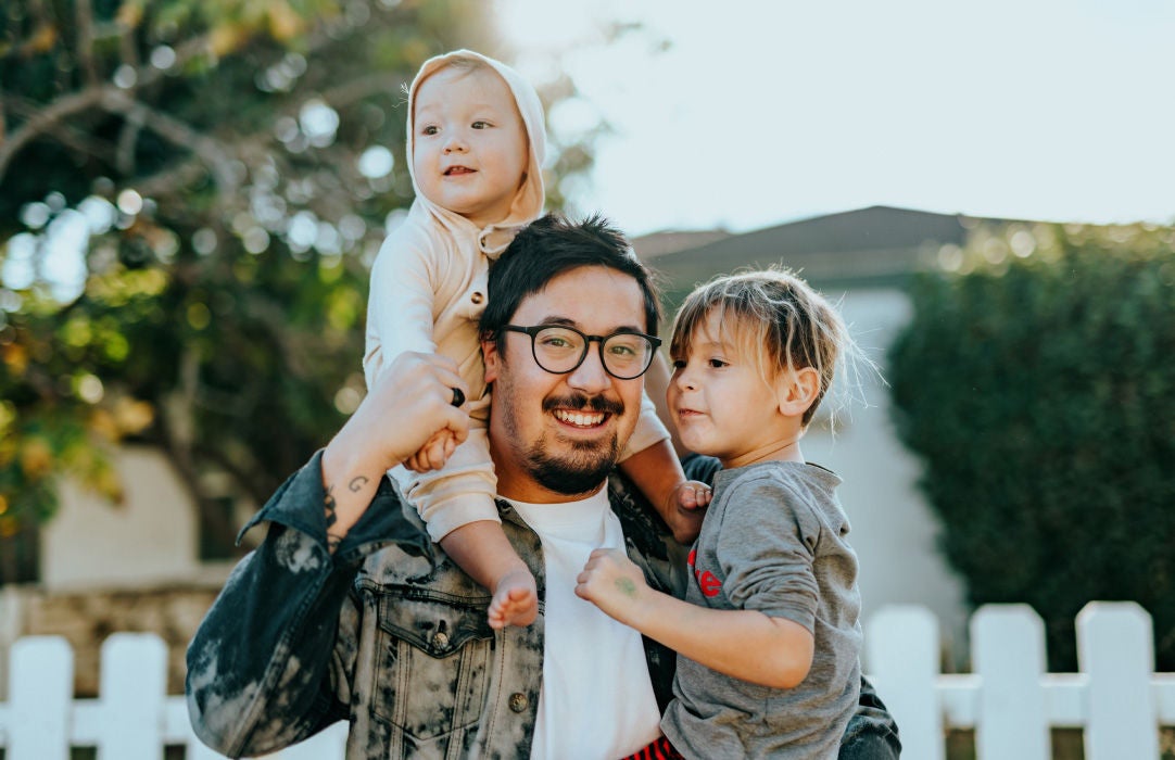 Man with family outside in yard.