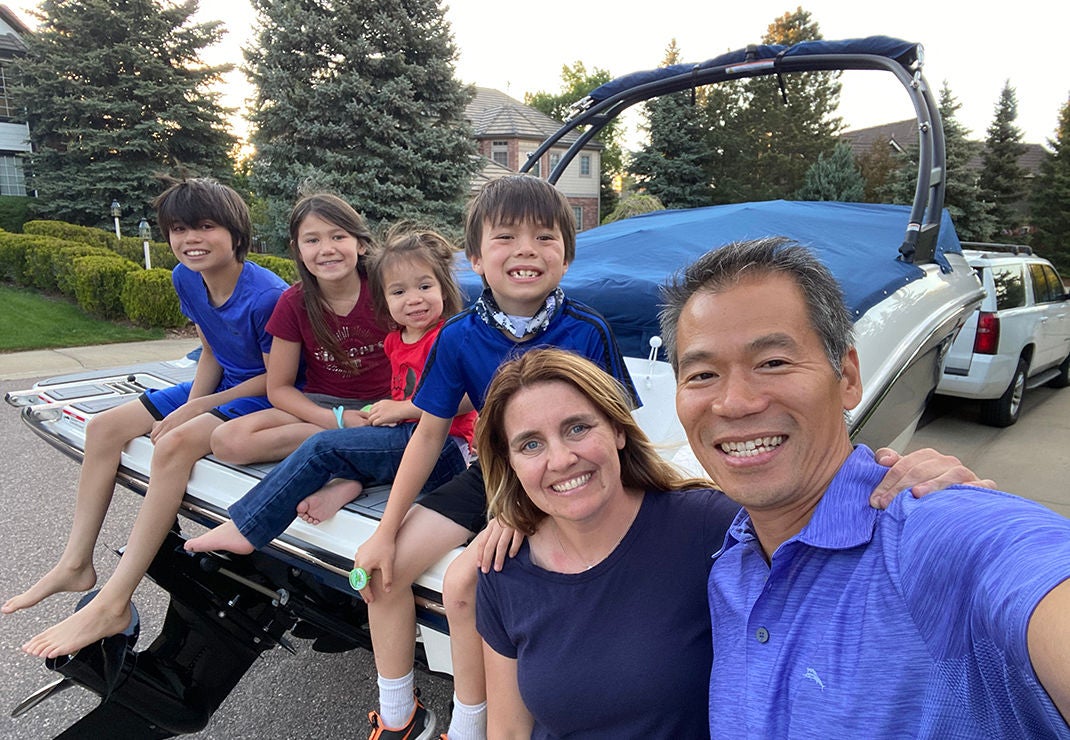 Slalom General Manager Binh Diep and family selfie of them sitting on a boat.