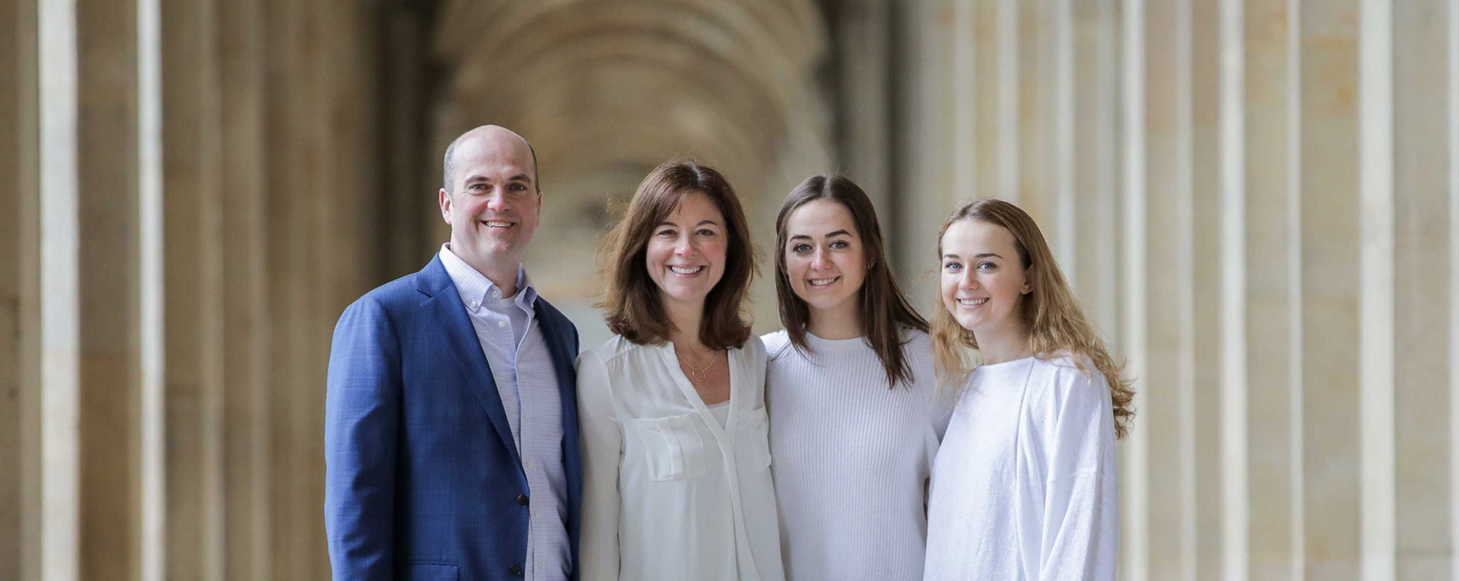 Slalom General Manager Todd Christy and family standing together in a stone colonnade.