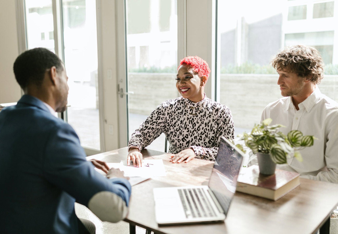 Three people meet to discuss banking matters.