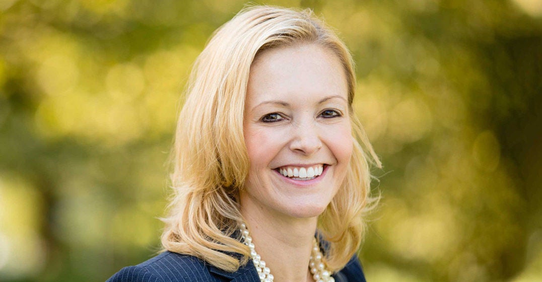 Headshot of Columbus general manager, Channie Mize, smiling against a blurred backdrop.