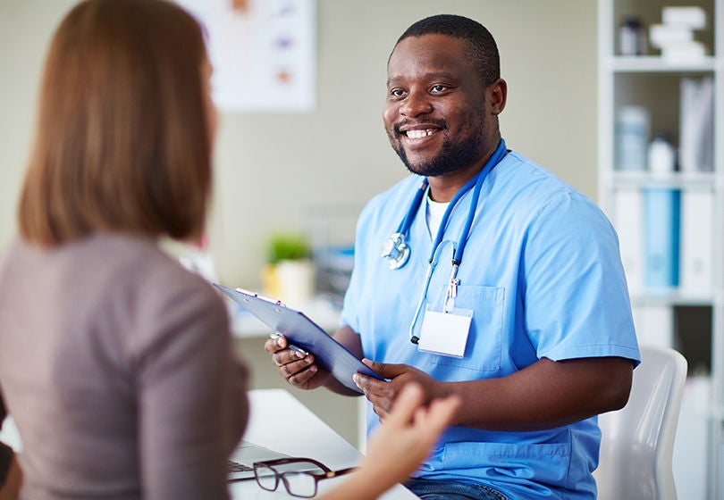 doctor with clipboard talking to patient