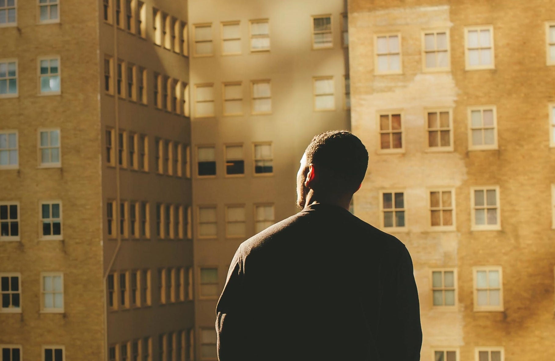 man looking at tall buildings