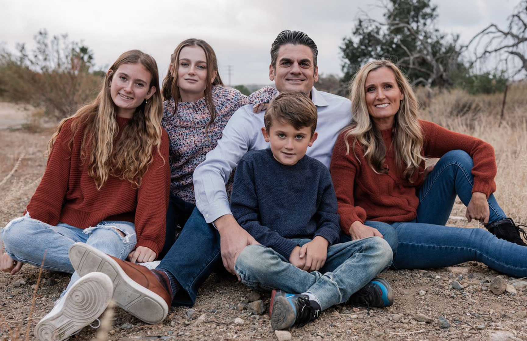 Slalom General Manager Don Piluso and family sitting in an arid landscape.