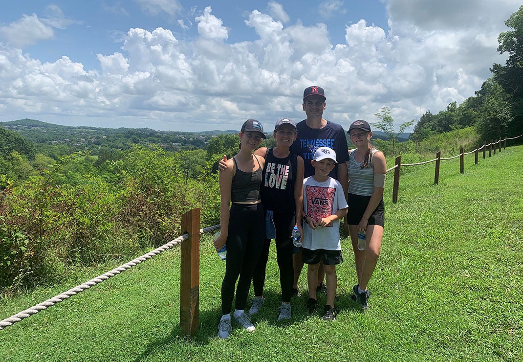 Slalom General Manager Don Piluso and family standing in lush green landscape.