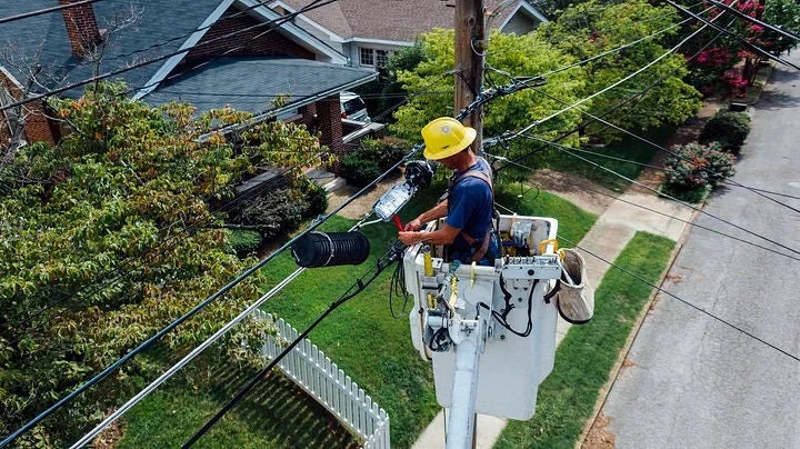 An electrian fixing a utility pole.