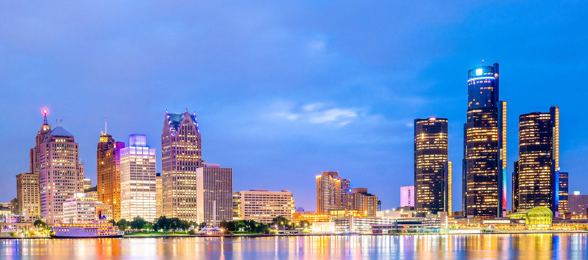 Skyline of Detroit, Michigan at sunset reflecting on the river. 