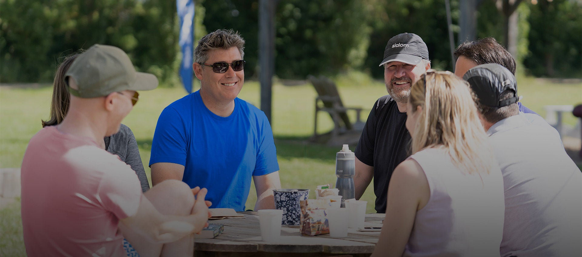 Six people collaborating around a table outdoors.