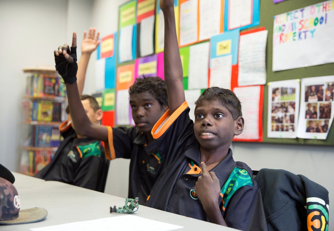 student raising hands mits