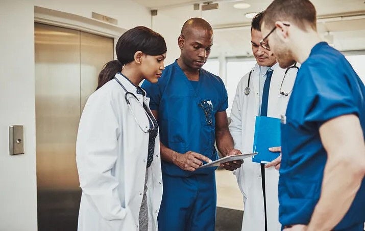 Doctors reviewing clipboard.