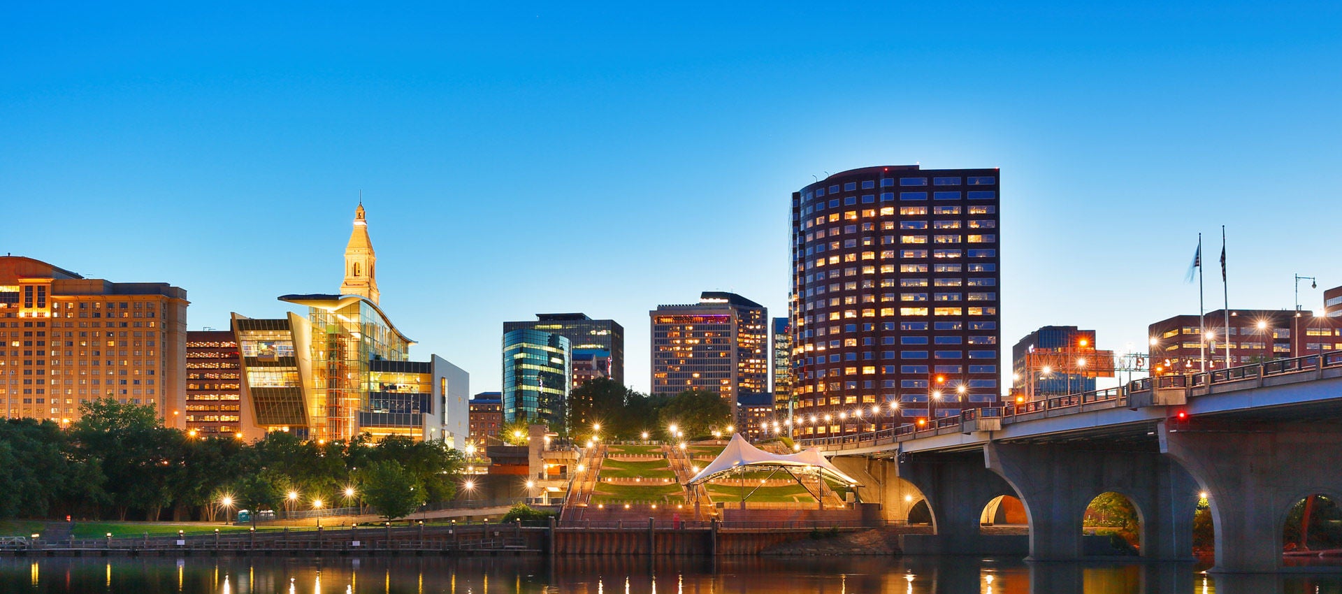 The Connecticut River. flows past skyline of Hartford, Connecticut at sunset.