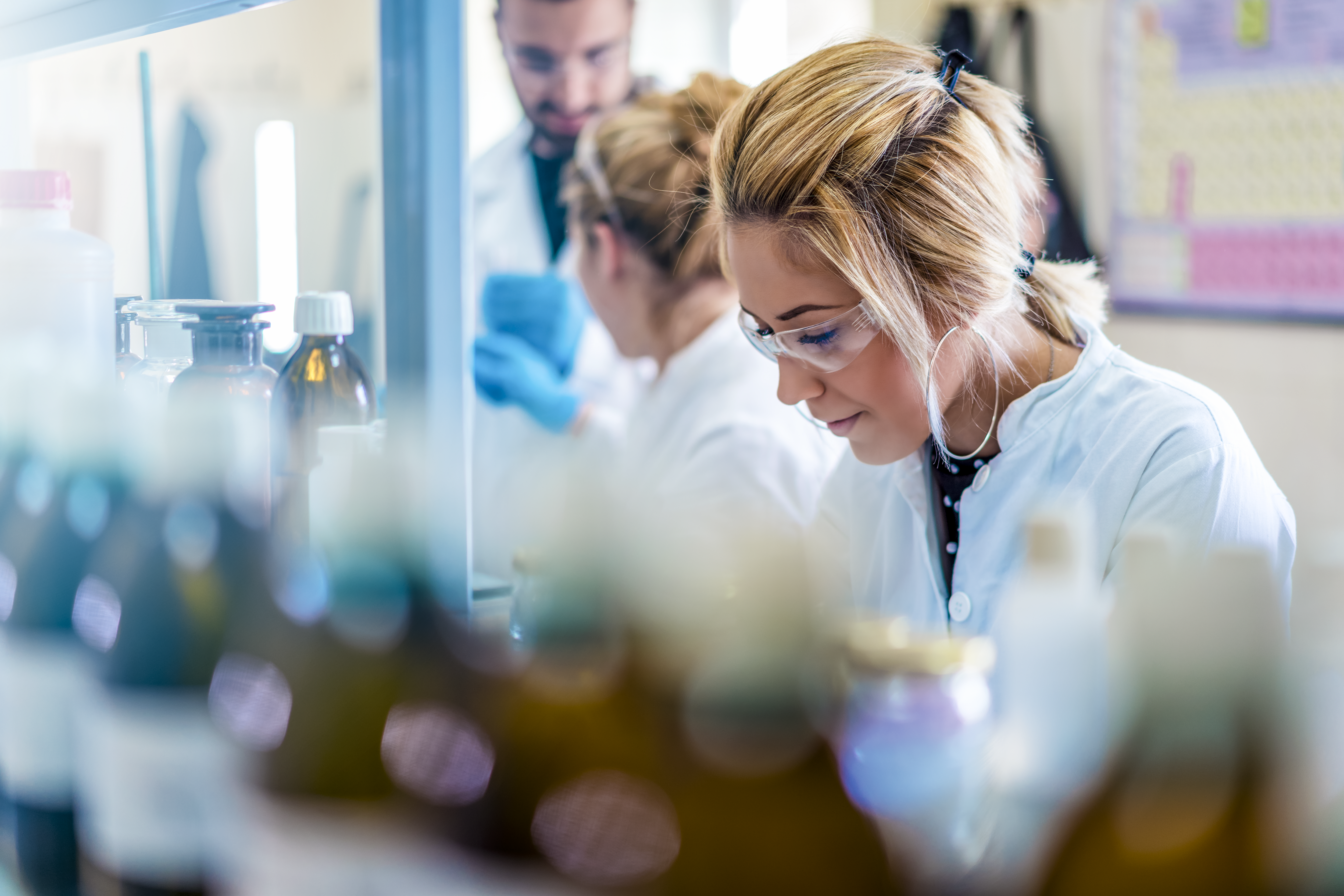 Beautiful young woman scientist in laboratory working. Young female scientist doing some research. Beautiful young woman scientist in laboratory working. Young female scientist doing some research.