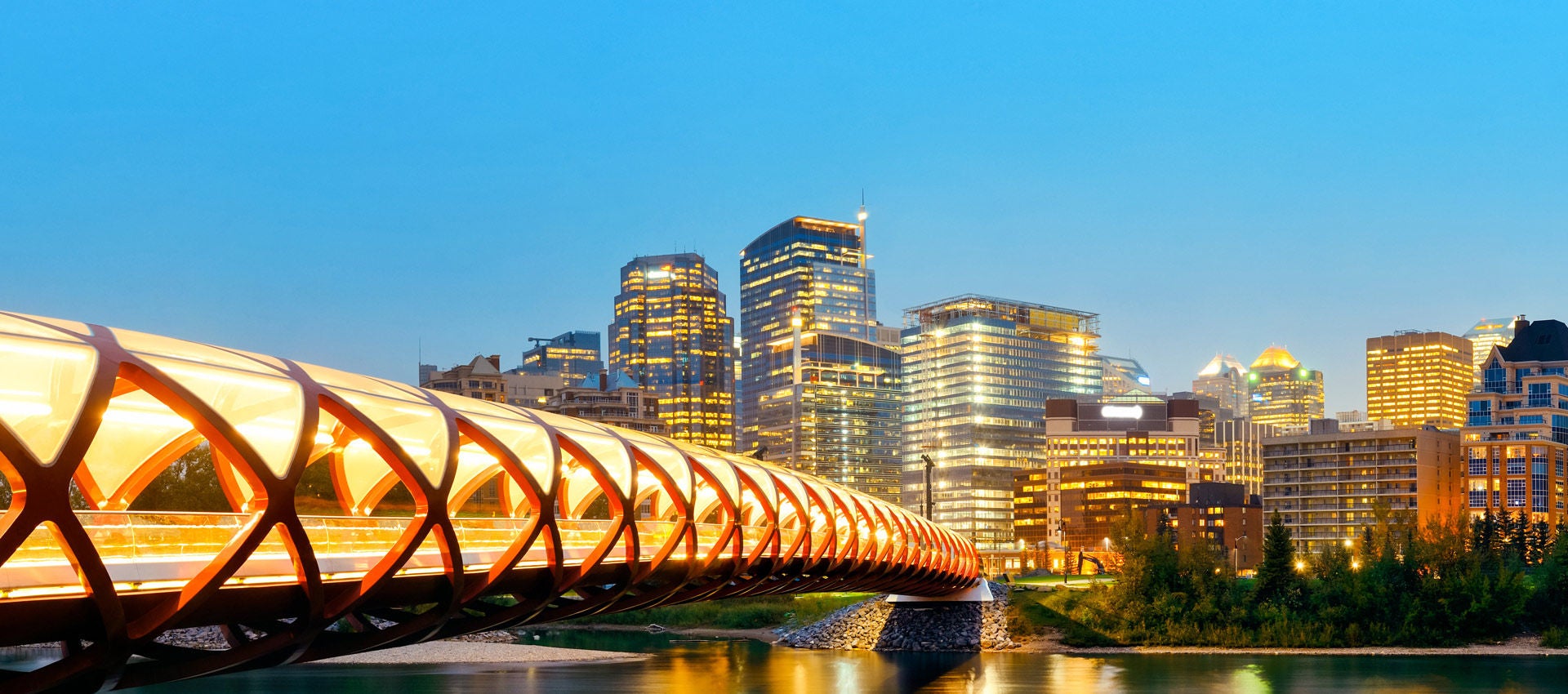 Calgary cityscape with Peace Bridge and downtown skyscrapers in Alberta at night, Canada.