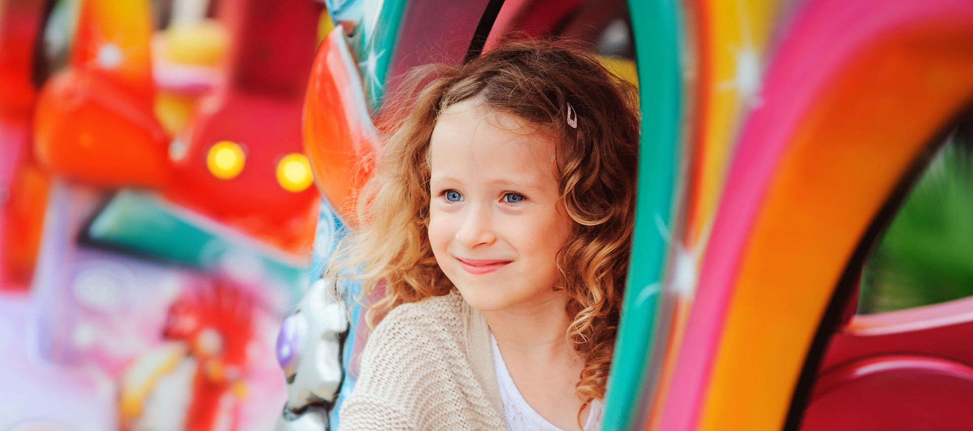 A young girl enjoys a ride at an amusement park.
