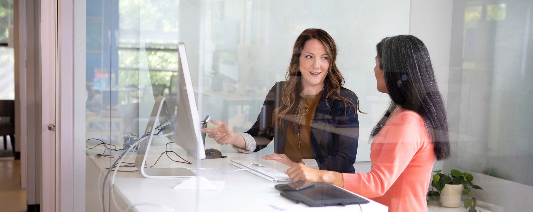 deux femmes travaillant devant un ordinateur dans un bureau