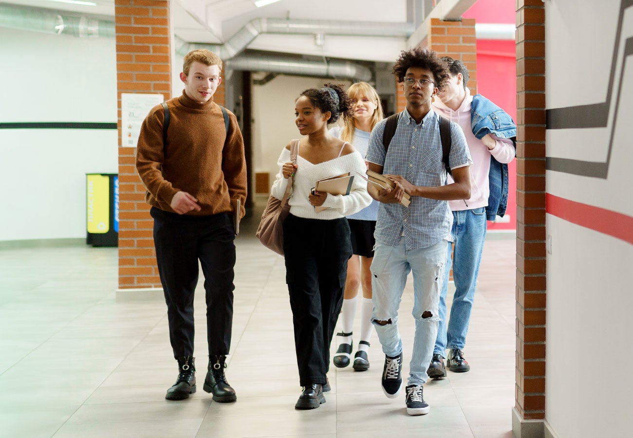 Group of students walking down a hall together.