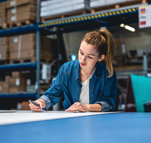 A woman reviews data in a warehouse. 