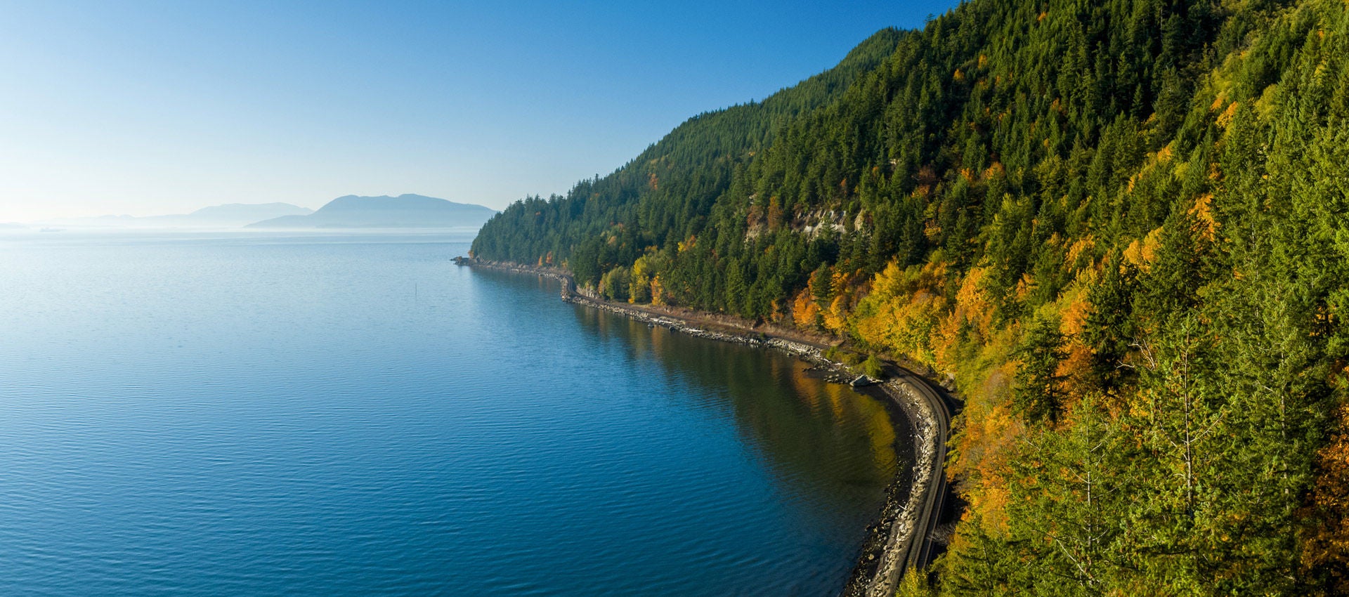 A beautiful sunny day unfolds above Pudget Sound and the shoreline. 