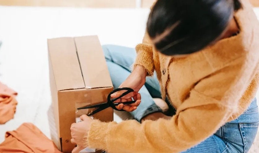 Woman opening a package with scissors