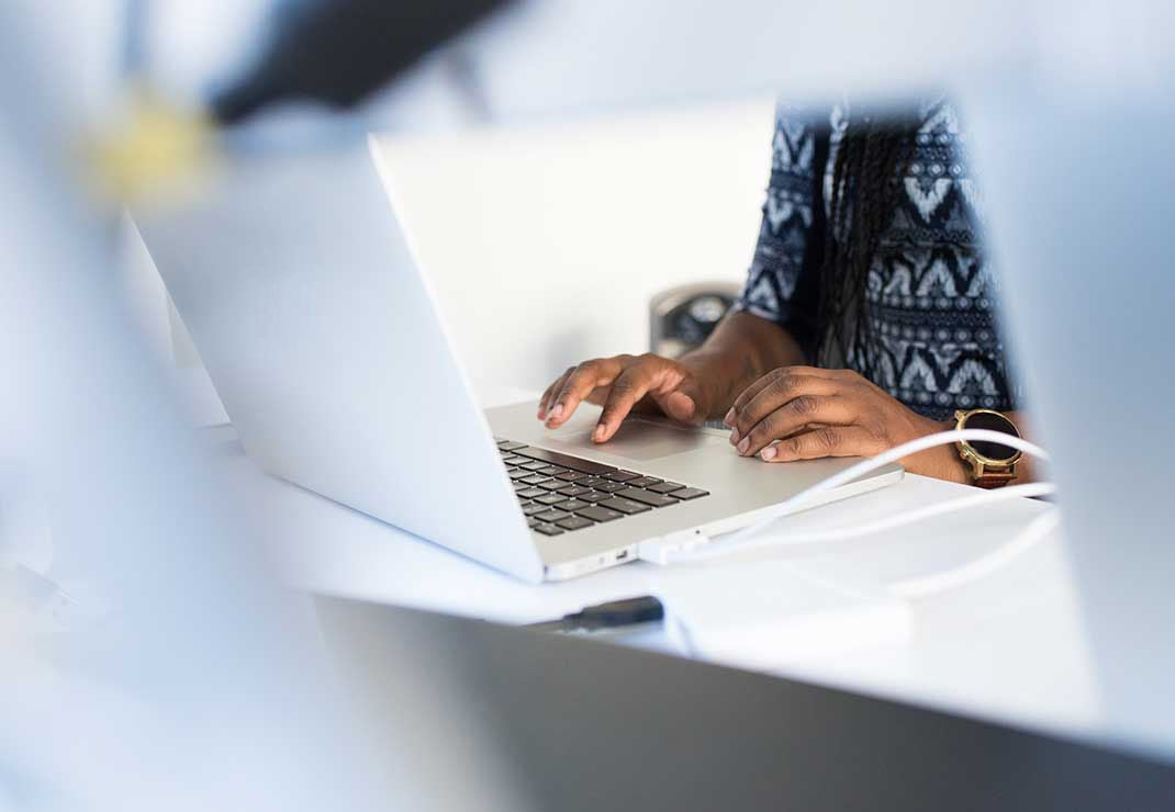 Woman typing on laptop computer.