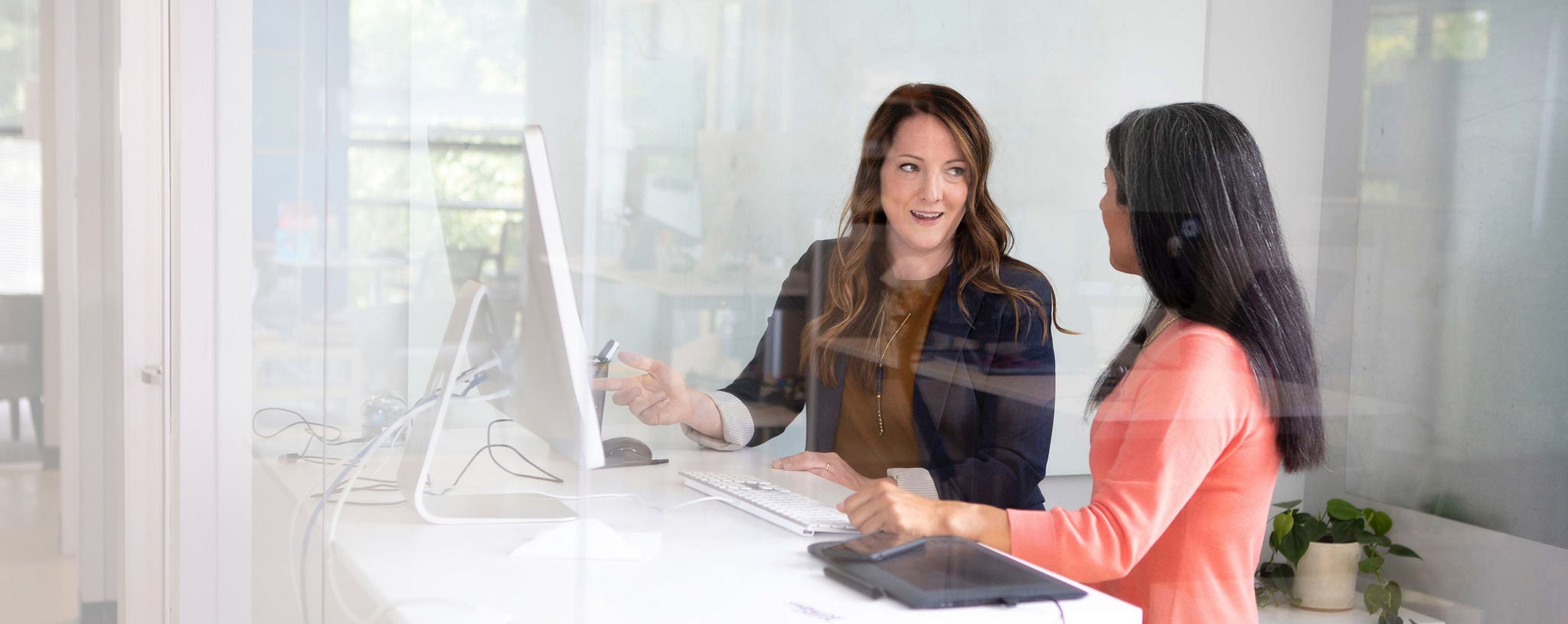 women talking in front of computer