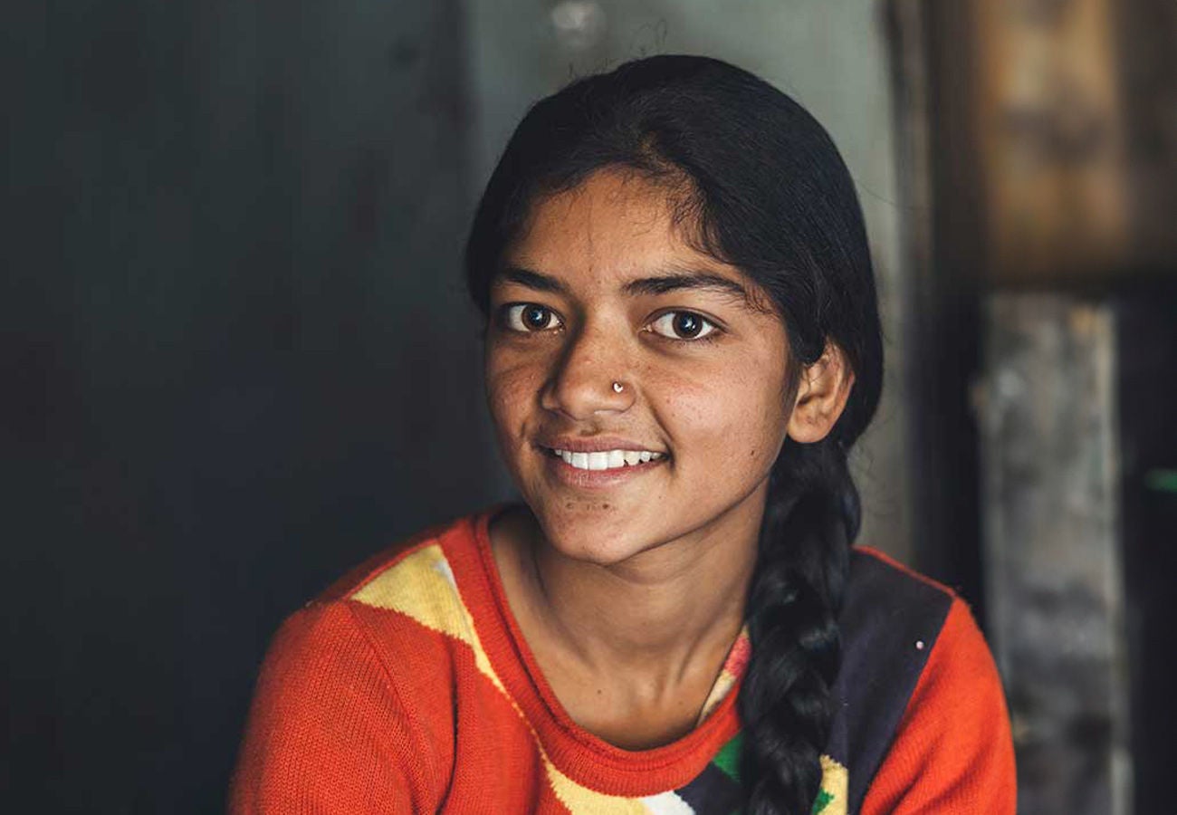 A smiling woman looks towards the camera.