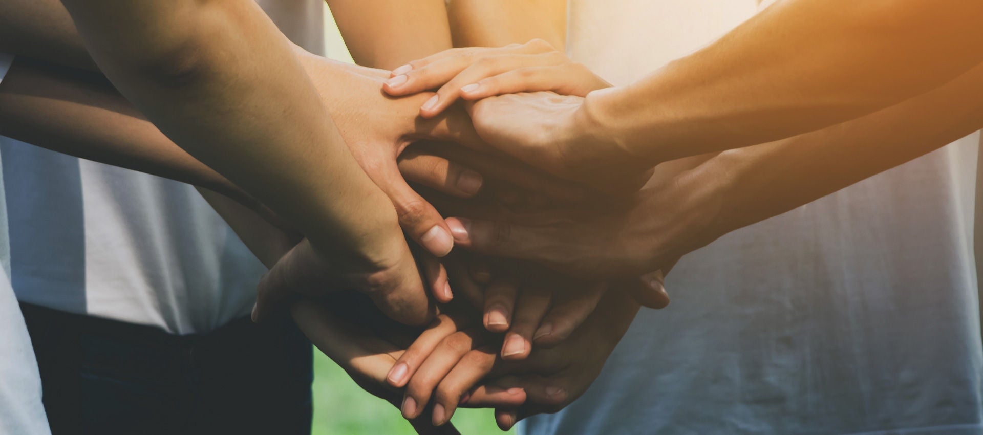 A group of people stack their hands together in the spirit of teamwork.