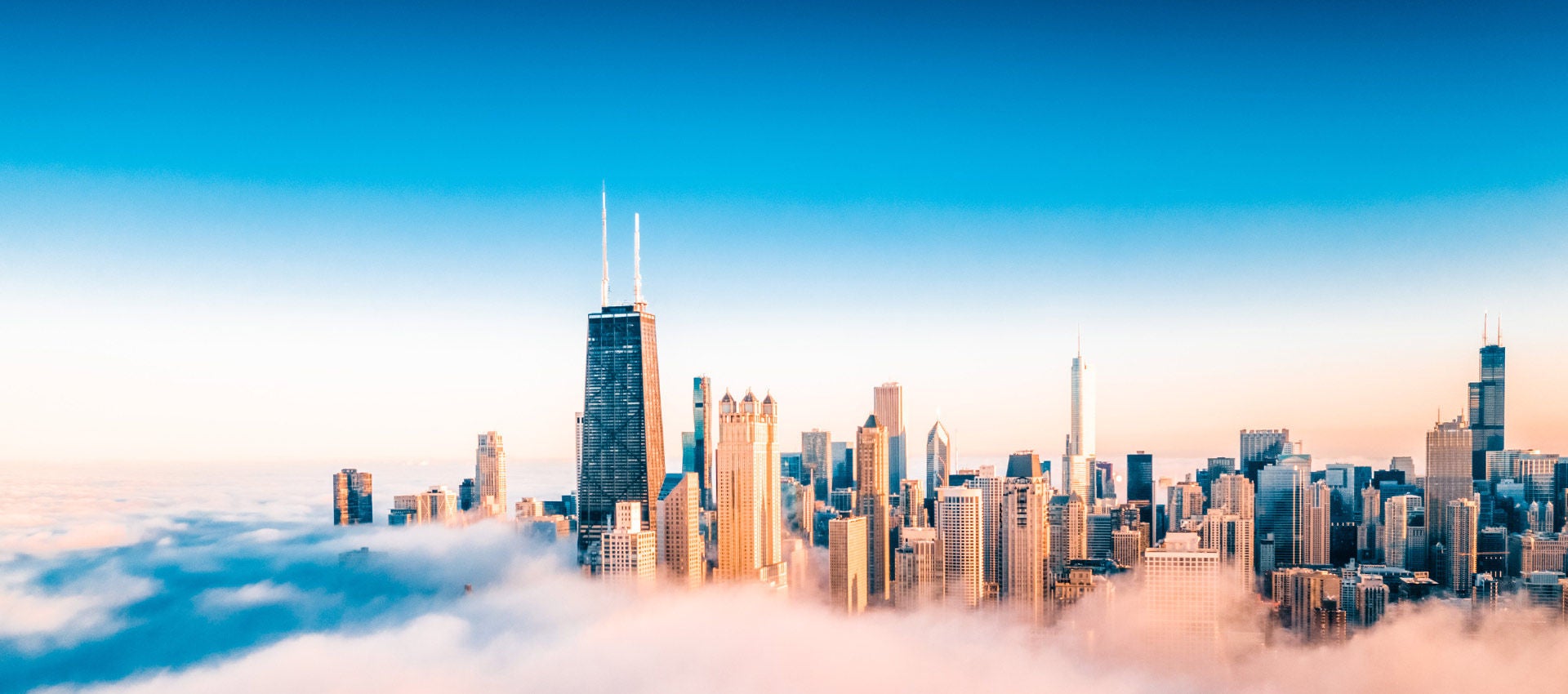 The Chicago skyline pops out over a cloud of fog along the shores of Lake Michigan. 