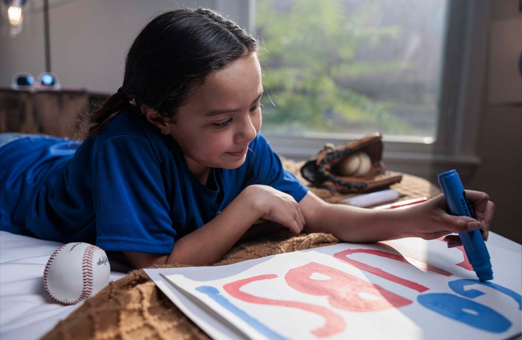 Young baseball fan making sign for upcoming baseball game.