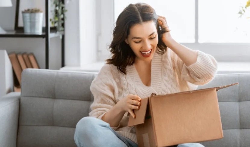 Woman opening box surprised.