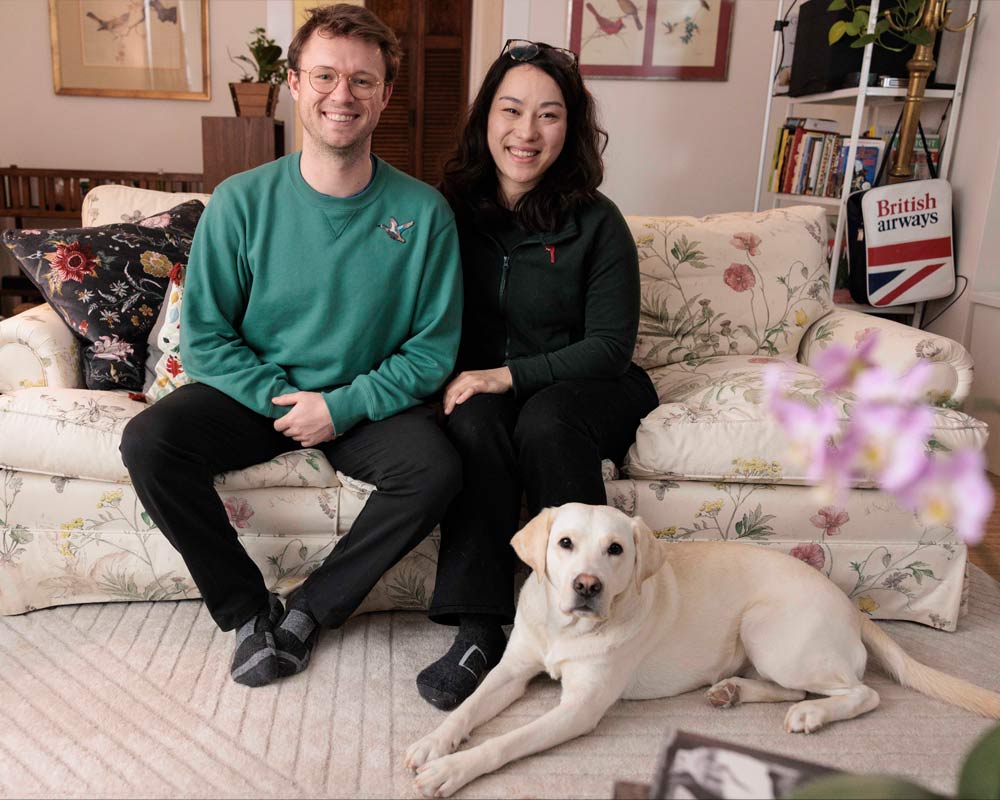足元に犬が寄り添ってソファに座る人々