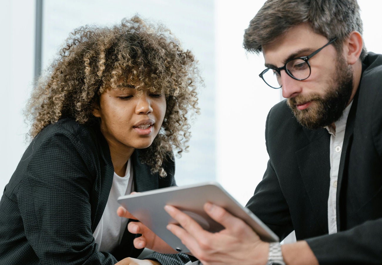 Two people work together with a tablet.