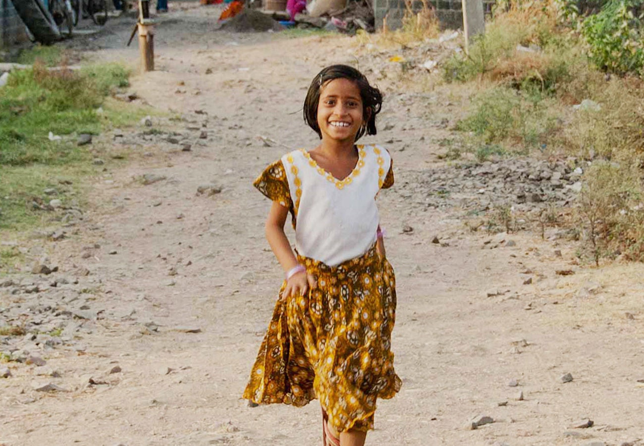 A happy young girl walking in a developing nation.
