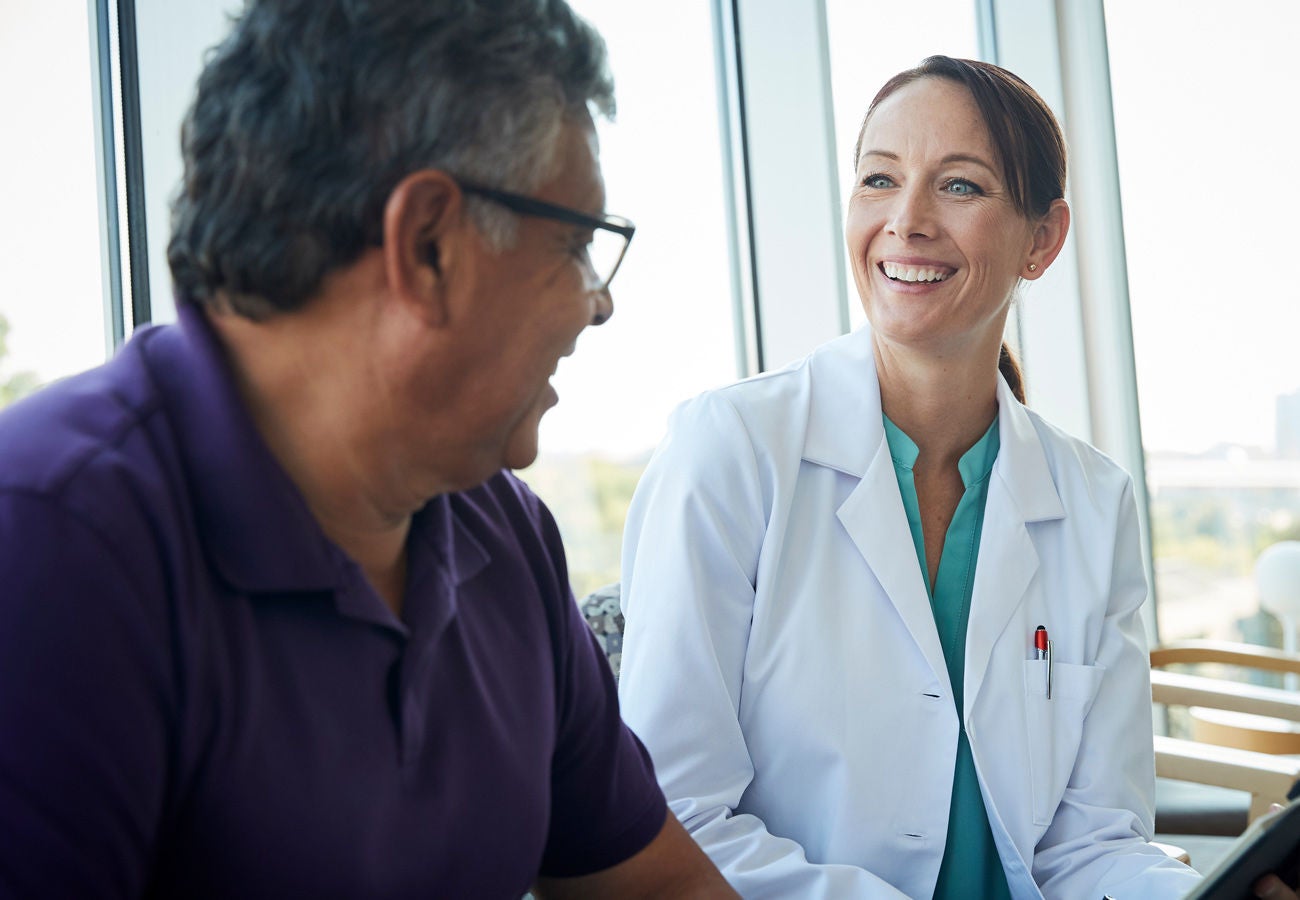 A doctor meets with a patient to discuss a health outcome.