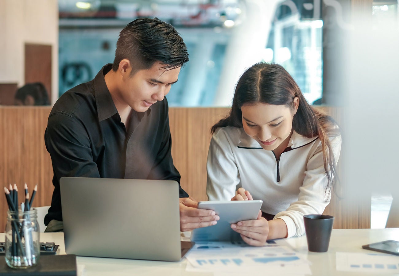 Two people work in the office with software.