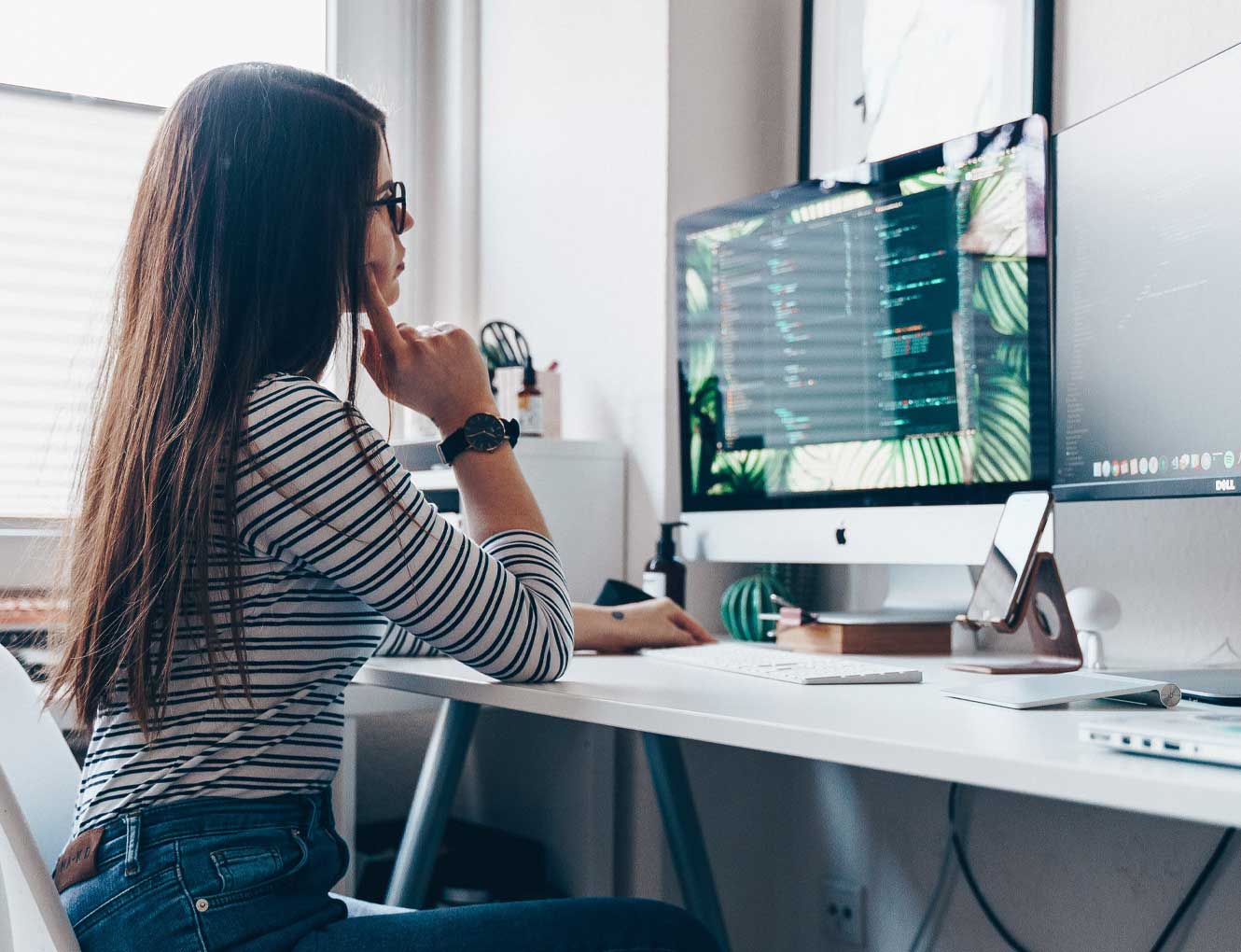 Woman working from home sitting down and looking at her computer.