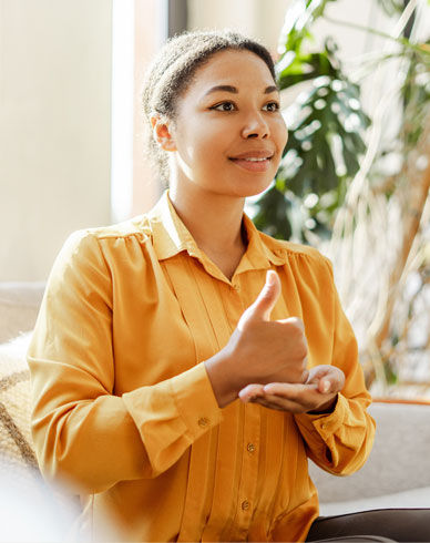 Woman in orange shirt uses sign language