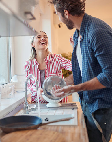 A couple does the dishes together.